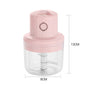 Pink hand juicer with clear container and measurements on a white background
