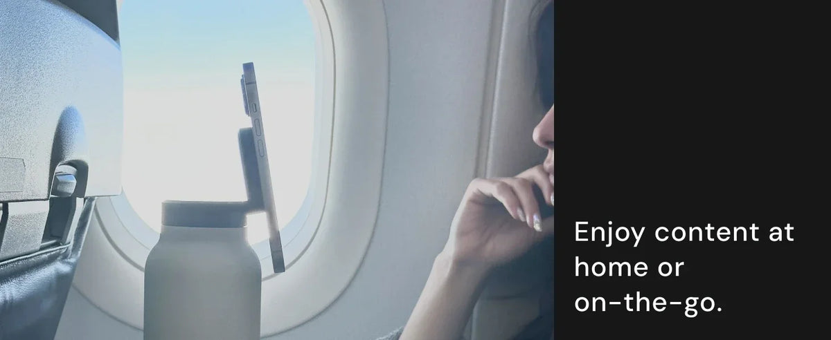 Person on an airplane looking out the window with a water bottle in hand, text 'Enjoy content at home or on-the-go'.
