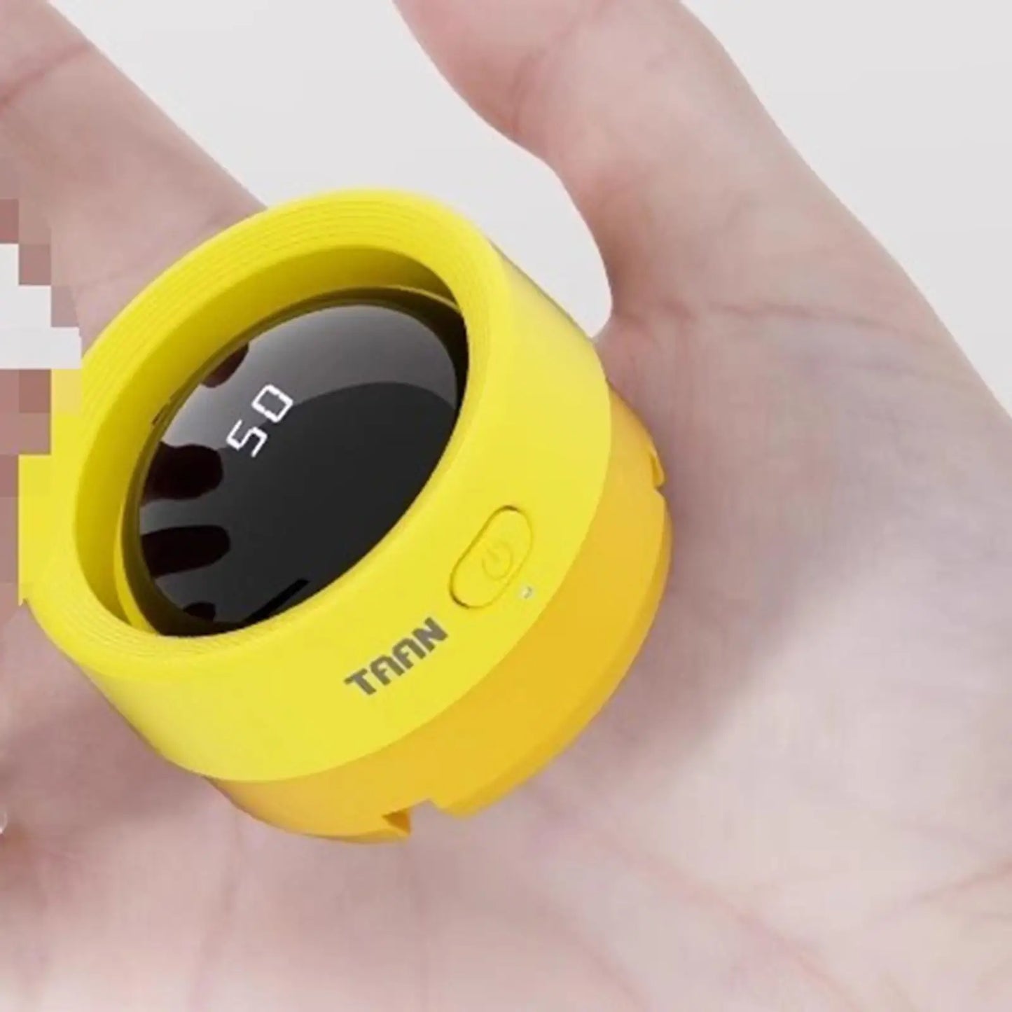 Yellow device with a digital display held in a hand against a white background