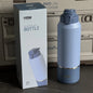 Blue TYESO vacuum insulated bottle with packaging in front of a vehicle