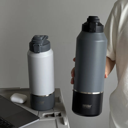 Two water bottles, one black and one white with gray accents, on a desk.