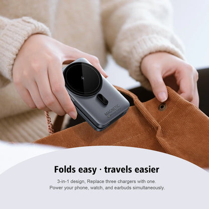 Person holding a compact charging device with text 'Folds easy, travels easier' on a blurred background.