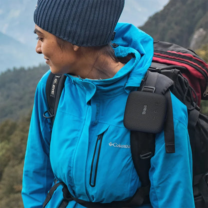 Person wearing a blue jacket with a backpack in a mountainous area