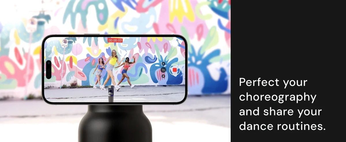 Smartphone displaying a dance video on a stand with colorful graffiti wall in the background