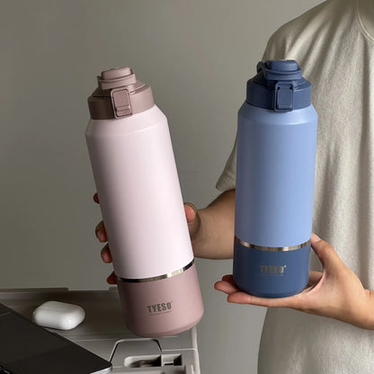 Two hands holding a pink and a blue insulated bottle with a neutral background