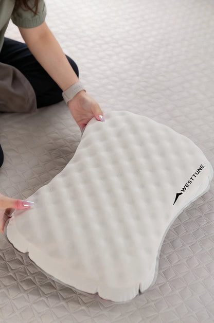 Westone ear pillow on a bed with a person holding it