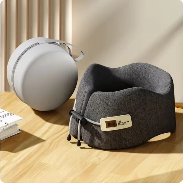 Gray travel neck pillow on a wooden surface with a beige background